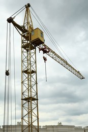 Photo of Construction site with tower crane under beautiful cloudy sky, low angle view