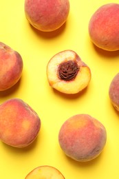 Photo of Delicious juicy peaches on yellow background, flat lay
