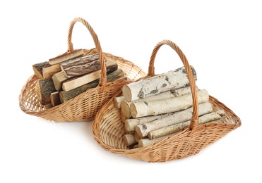 Wicker baskets with firewood on white background