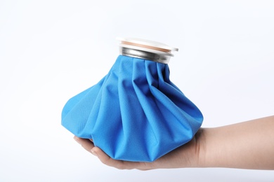 Photo of Woman holding ice pack against white background, closeup