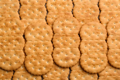 Many delicious crackers as background, top view