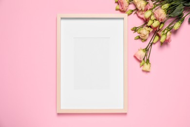 Photo of Empty photo frame and beautiful flowers on pink background, flat lay. Space for design