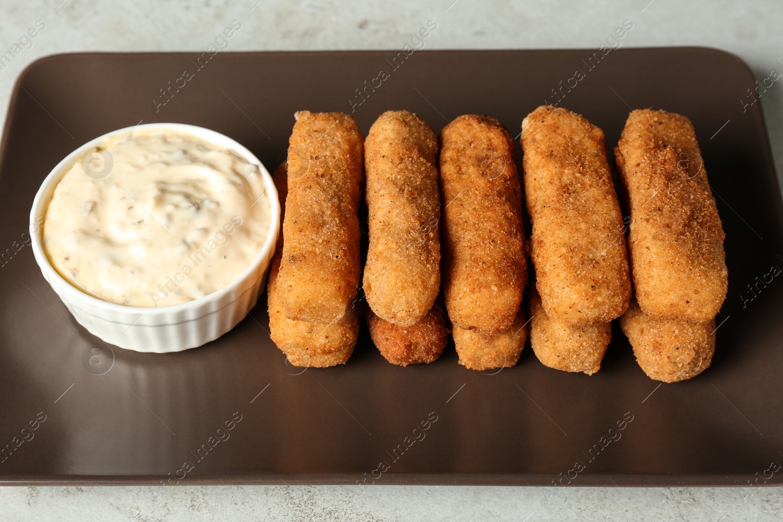 Photo of Plate with cheese sticks and sauce on table, closeup