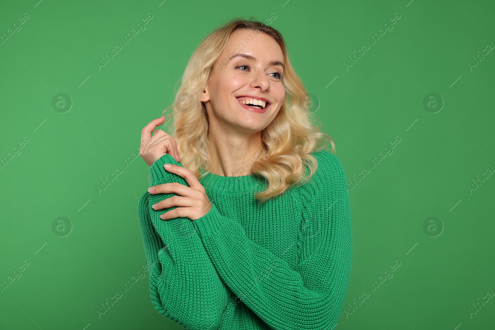 Photo of Happy woman in stylish warm sweater on green background