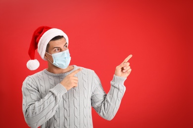 Man wearing Santa hat and medical mask on red background