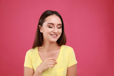 Photo of Beautiful young woman in casual outfit on crimson background