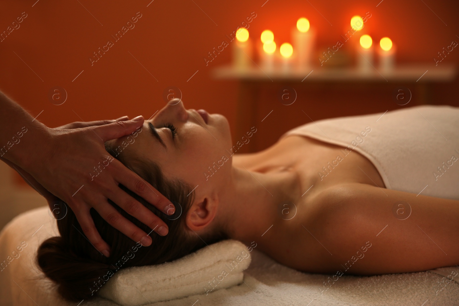 Photo of Young woman receiving head massage in spa salon