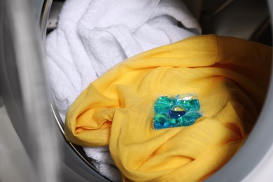 Photo of Laundry detergent capsule in washing machine drum, closeup view