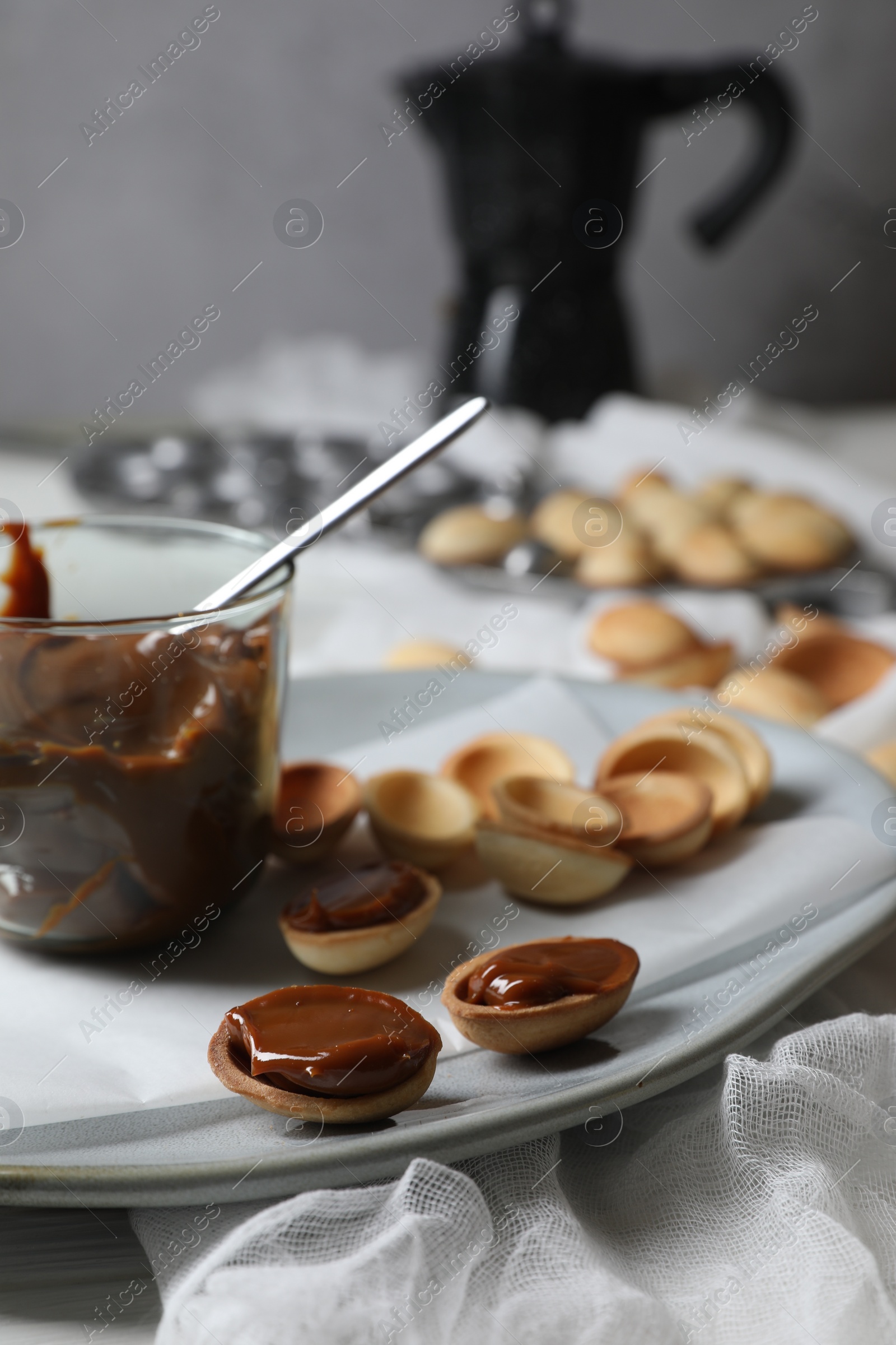 Photo of Delicious walnut shaped cookies with condensed milk on plate, closeup