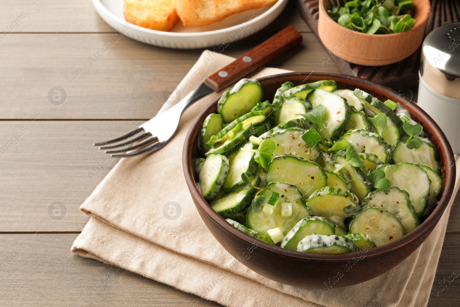 Photo of Delicious cucumber salad served on wooden table