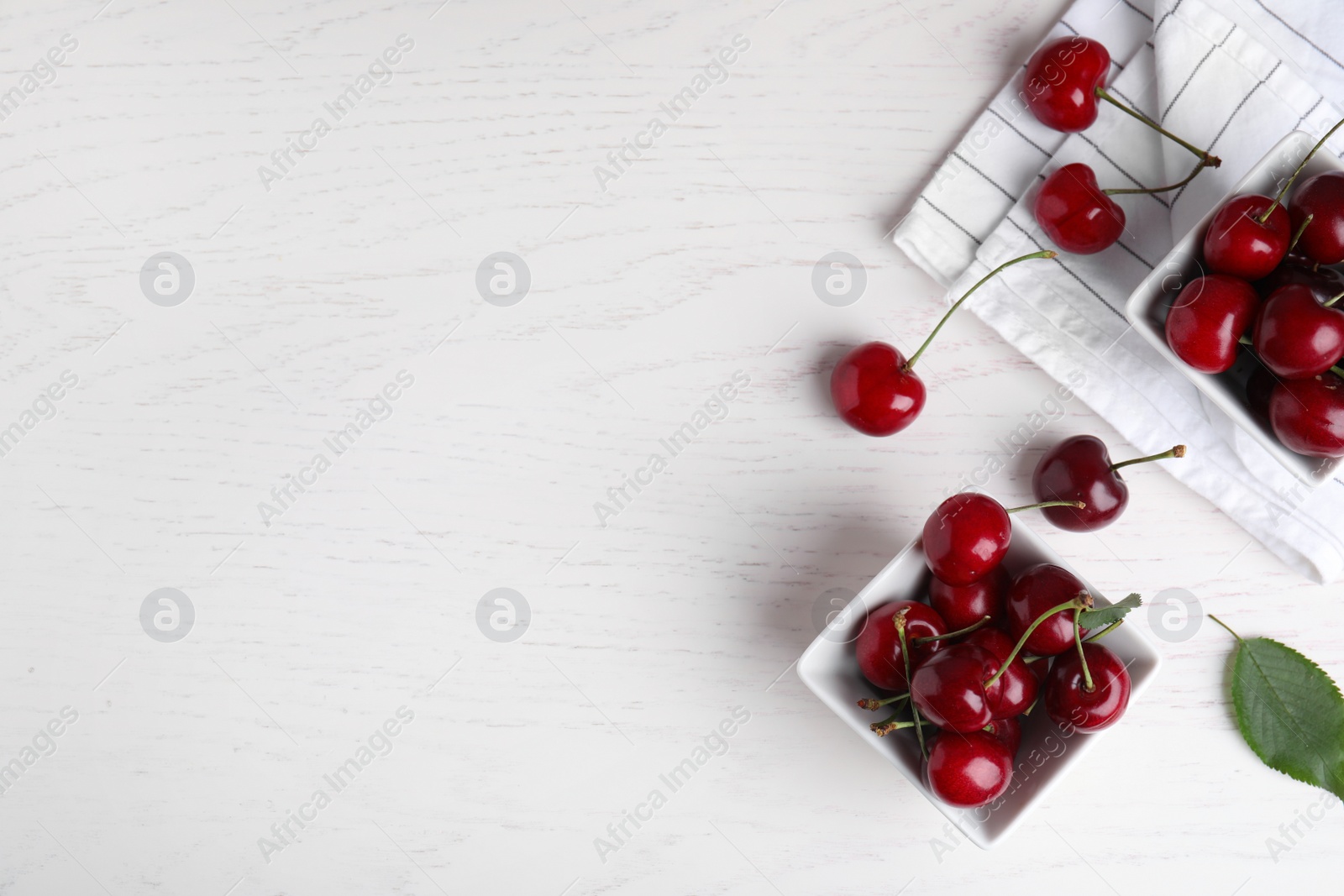 Photo of Flat lay composition with sweet cherries on white wooden table. Space for text