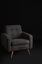 Photo of Stylish comfortable grey armchair on black background