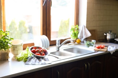 Photo of Blurred view of stylish kitchen interior with sink and products