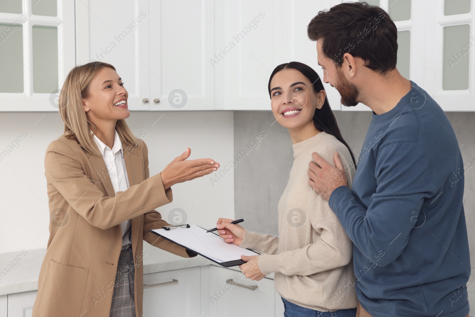 Photo of Real estate agent and couple signing contract in new apartment