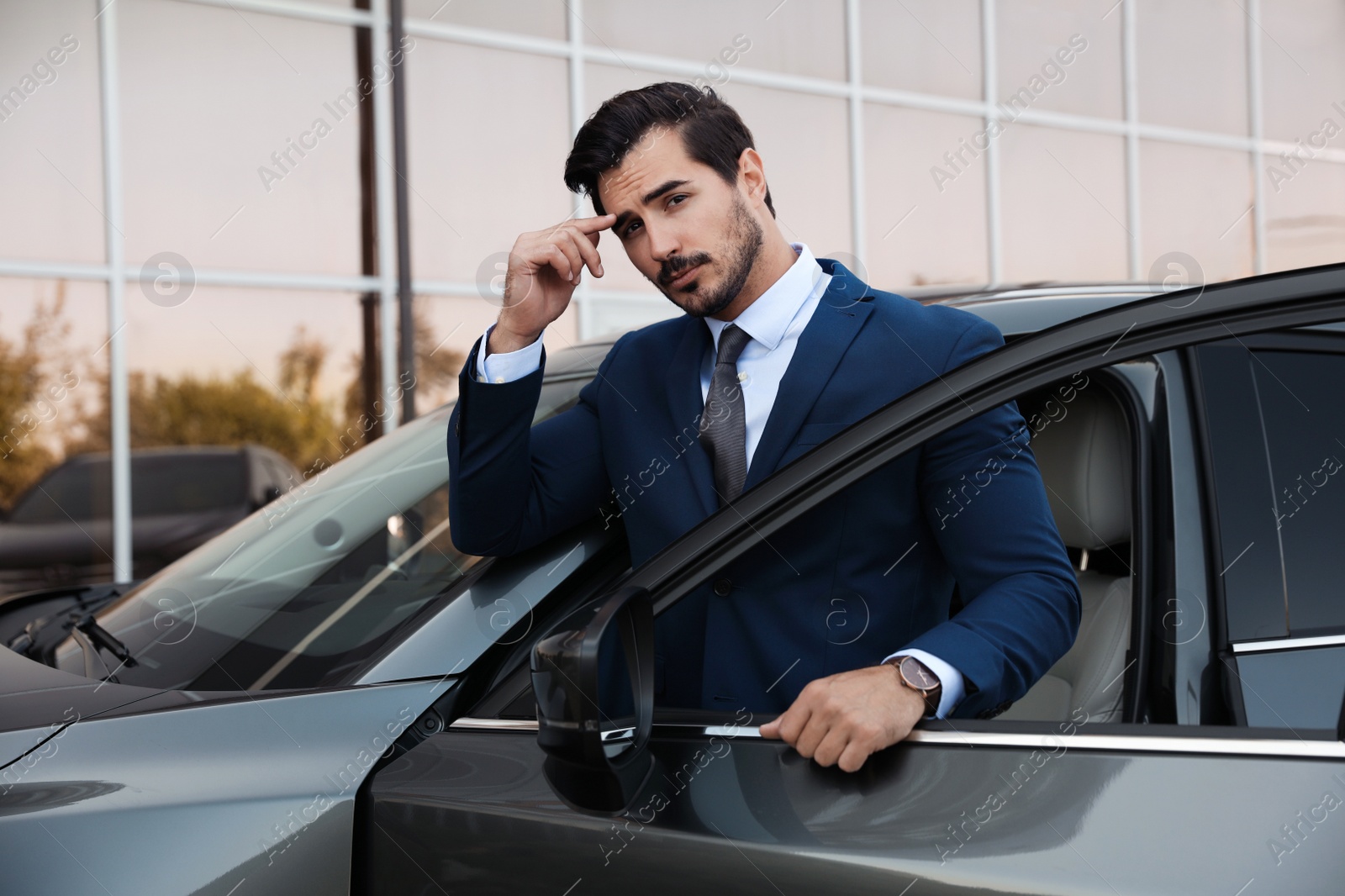 Photo of Attractive young man near luxury car outdoors