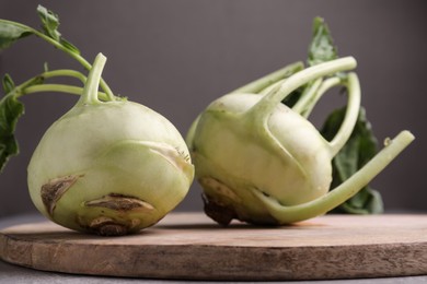 Photo of Whole ripe kohlrabi plants on wooden board, closeup