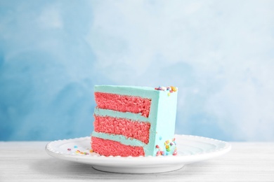 Photo of Slice of fresh delicious birthday cake on table against color background