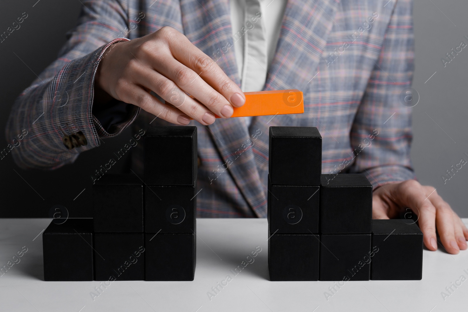 Photo of Businesswoman building bridge with colorful blocks at table, closeup. Connection, relationships and deal concept