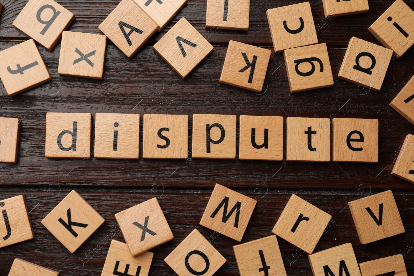 Photo of Squares with word Dispute on dark wooden table, flat lay