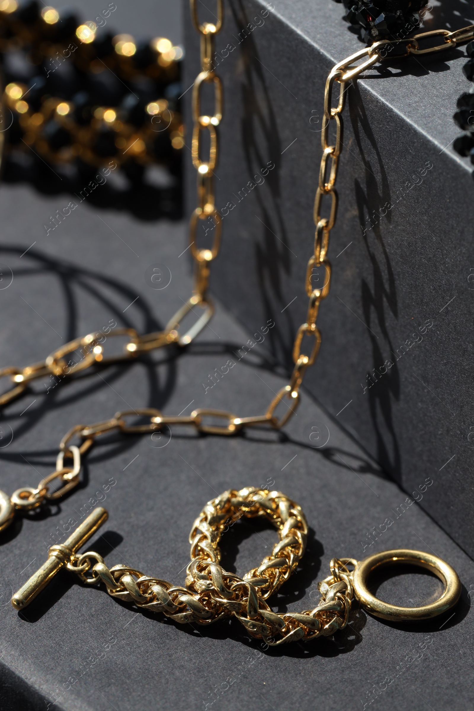 Photo of Presentation of metal chains on black table, closeup. Luxury jewelry