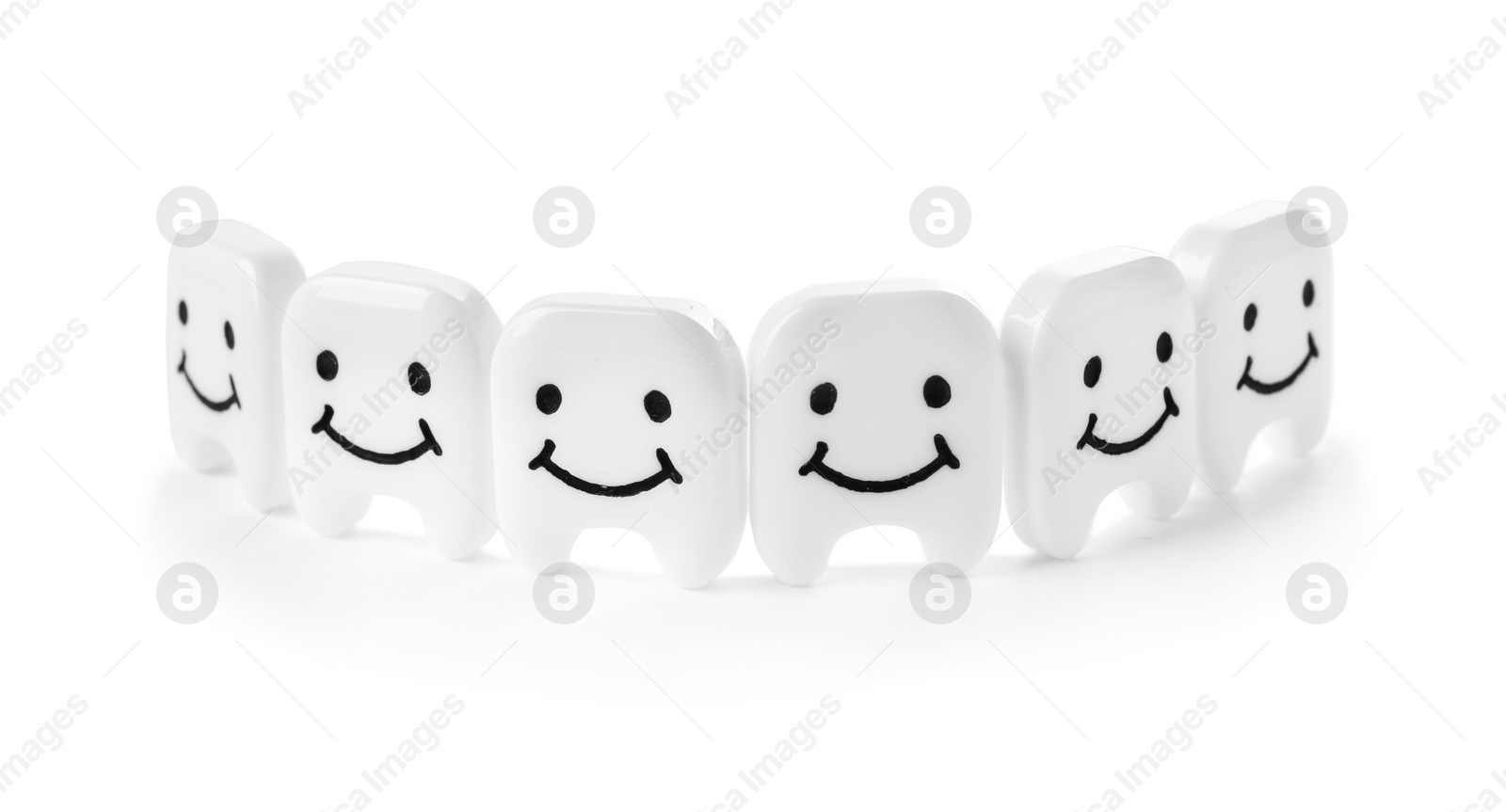 Photo of Small plastic teeth with happy faces on white background