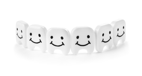 Small plastic teeth with happy faces on white background