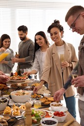 Photo of Group of people enjoying brunch buffet together indoors