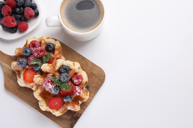 Photo of Delicious Belgian waffles with fresh berries on white table, flat lay. Space for text