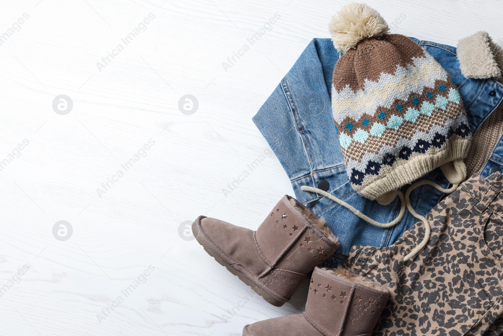 Photo of Warm child clothes and shoes on white wooden background, flat lay. Space for text