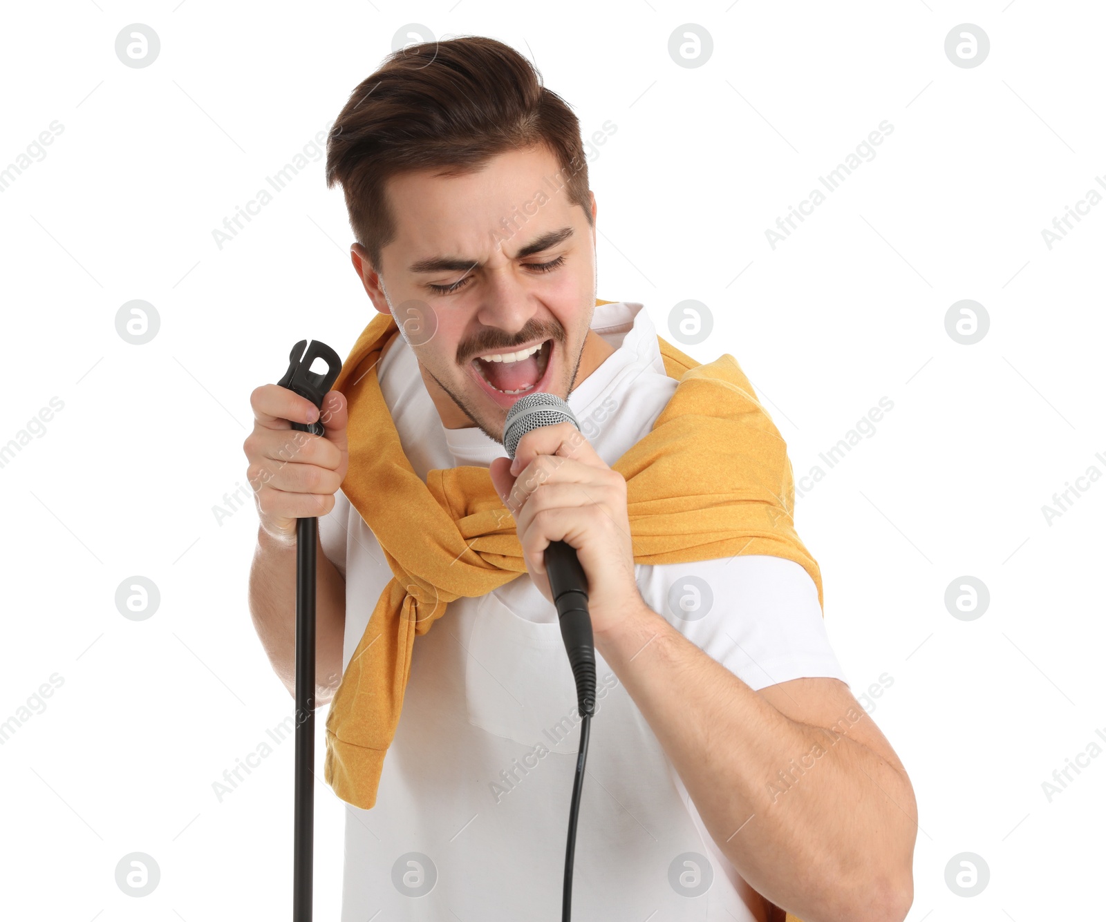 Photo of Young handsome man in casual clothes singing with microphone on white background