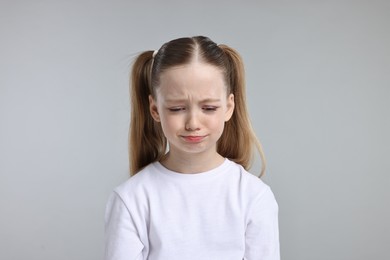 Photo of Portrait of sad girl on light grey background