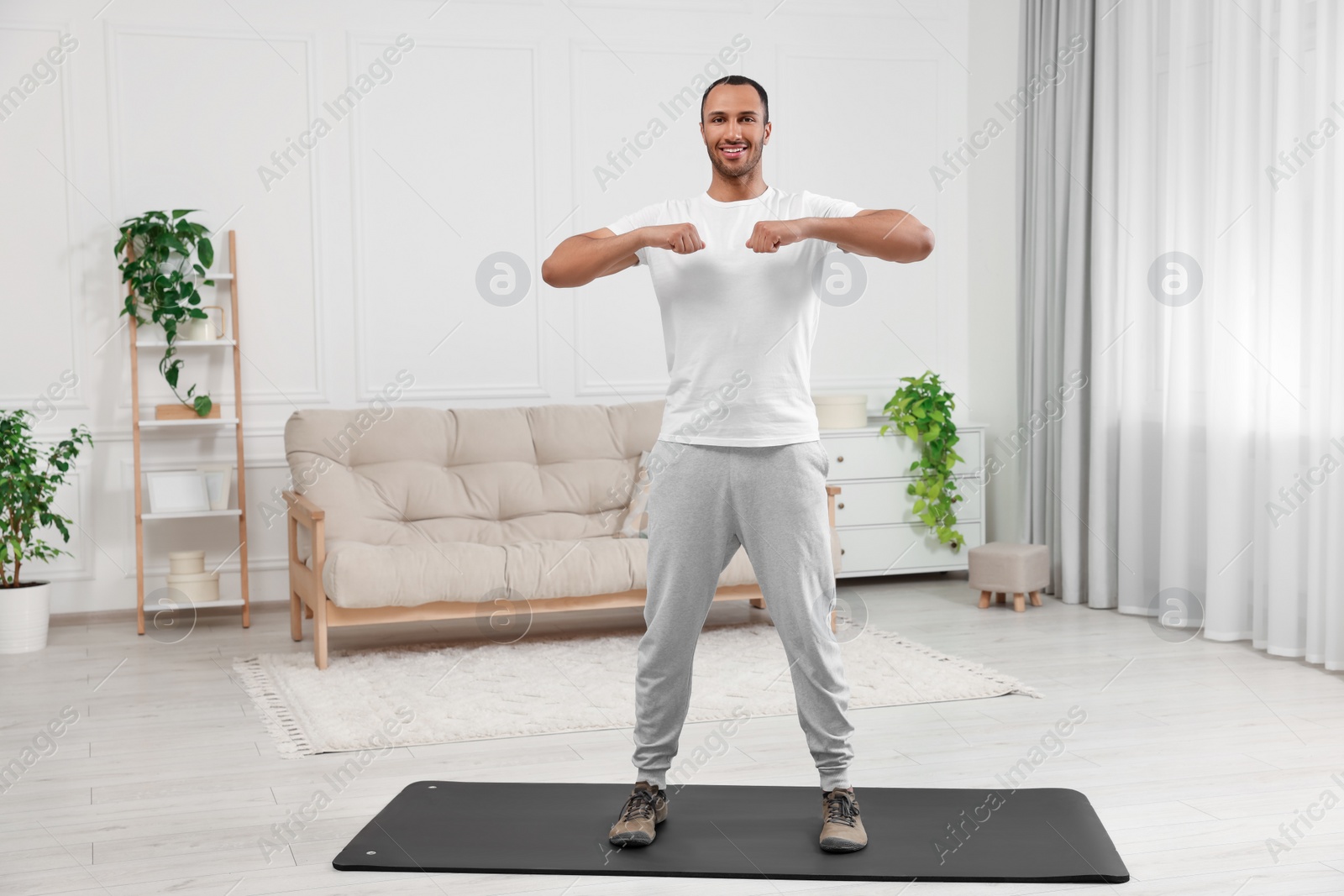 Photo of Man doing morning exercise on fitness mat at home