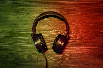 Photo of Stylish headphones on wooden background, top view