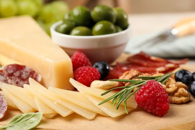 Photo of Snack set with delicious Parmesan cheese on wooden board, closeup