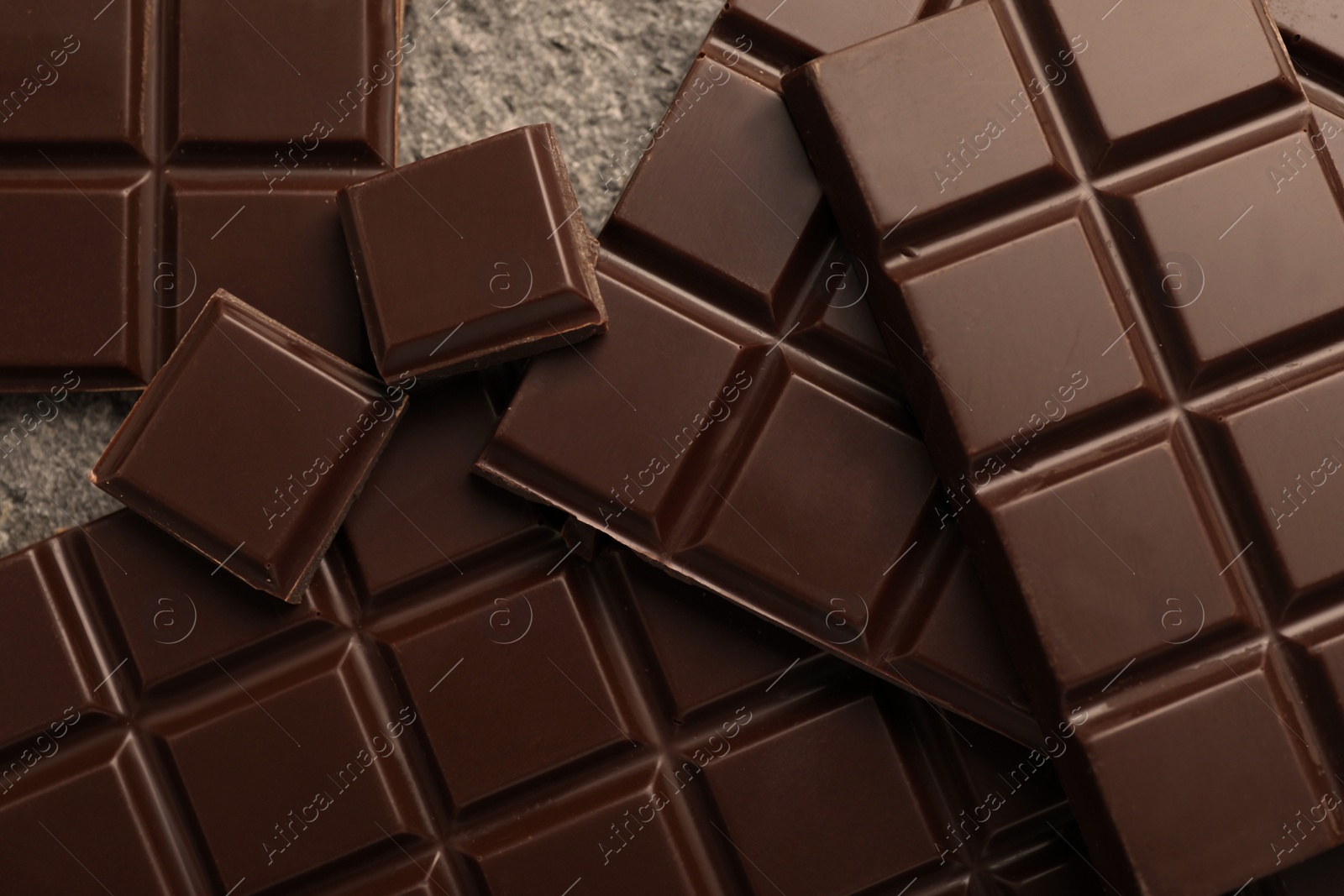 Photo of Delicious dark chocolate on grey table, closeup