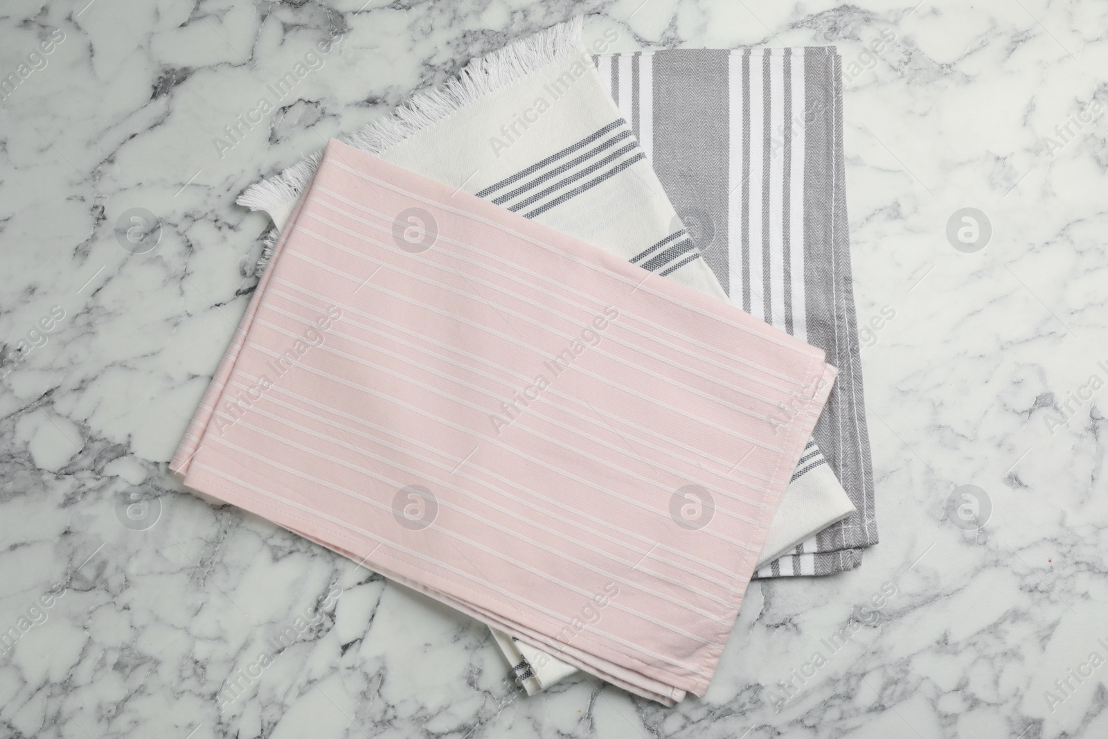 Photo of Different kitchen towels on white marble table, top view