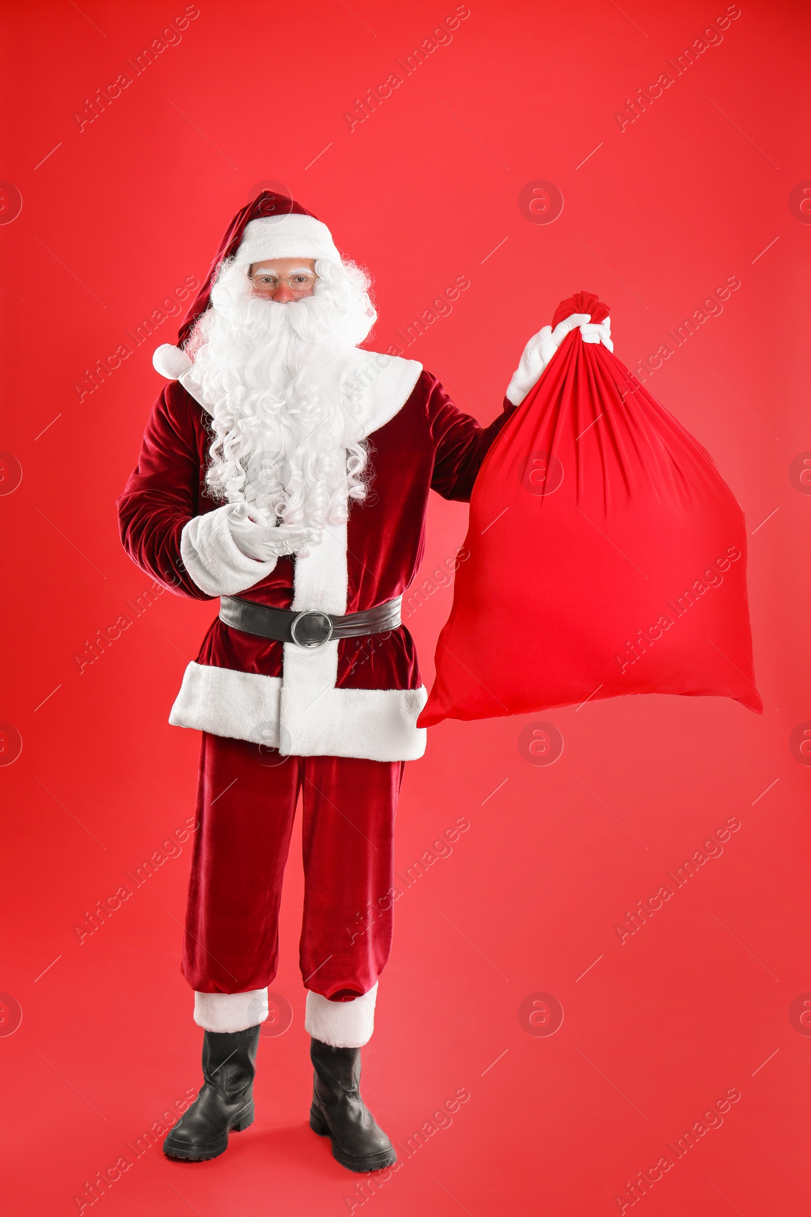 Photo of Santa Claus with sack on red background