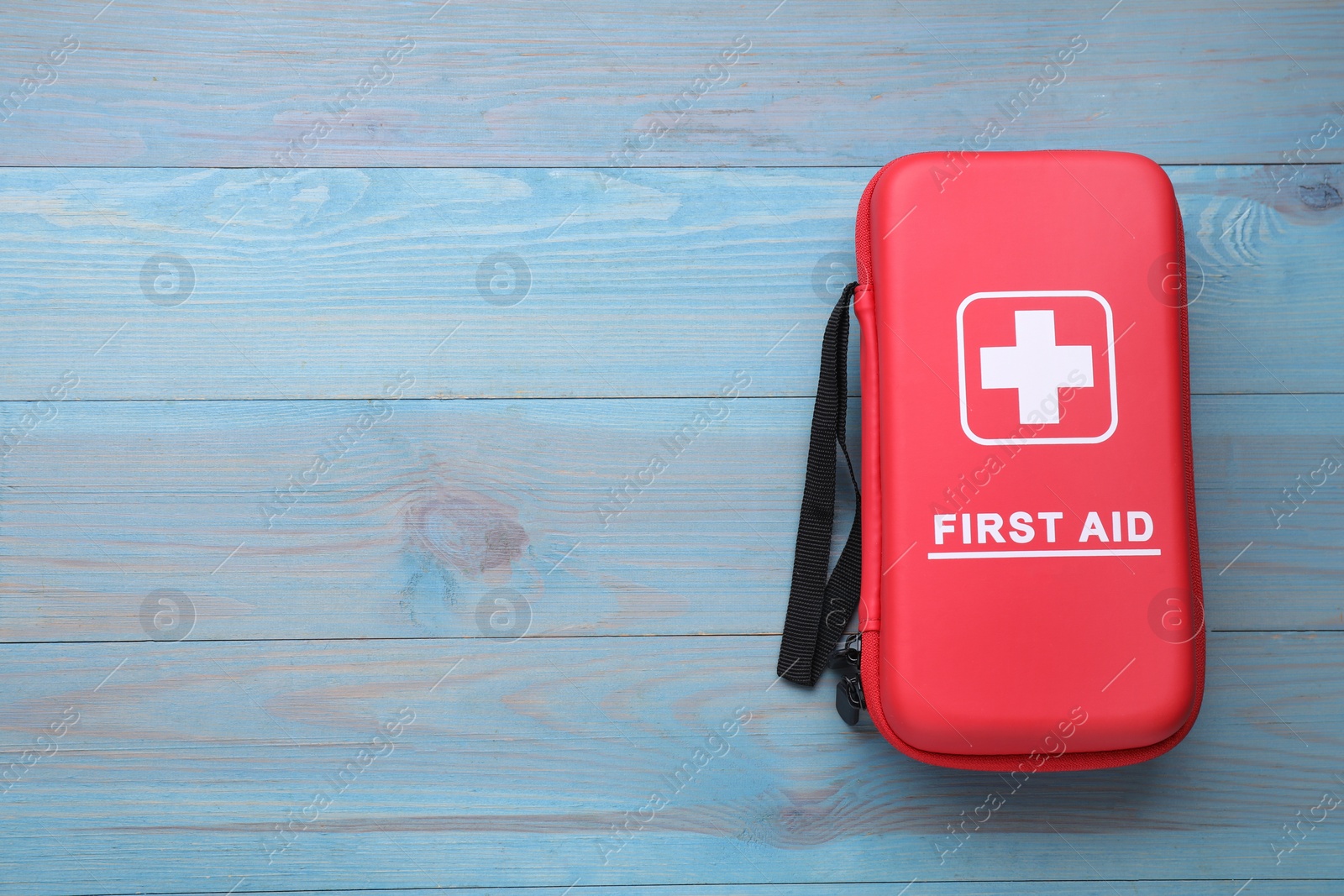 Photo of Medicine bag on blue wooden table, top view with space for text. First aid kit