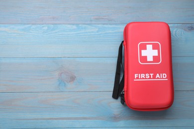 Medicine bag on blue wooden table, top view with space for text. First aid kit