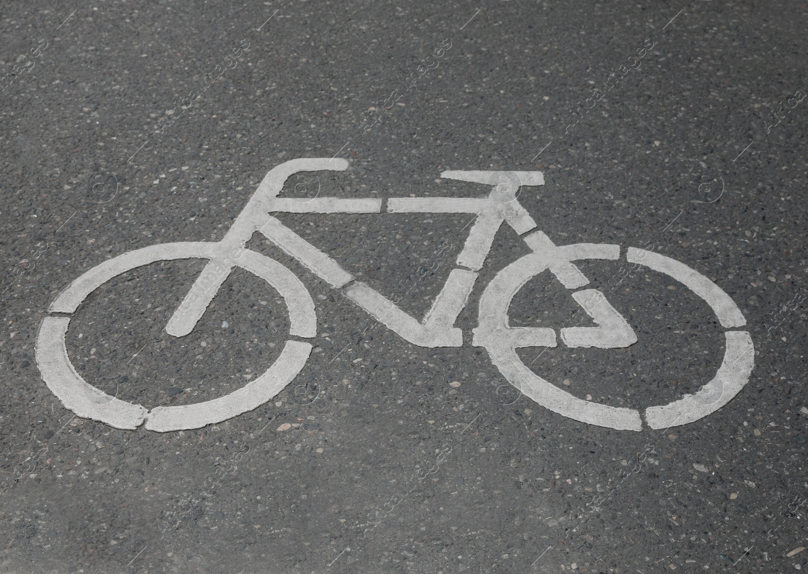 Photo of Bicycle lane with white sign painted on asphalt