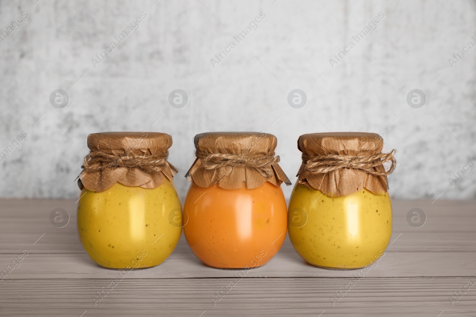 Photo of Jars with canned fruit jams on wooden table