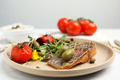 Tasty salmon with salad and capers on white table, closeup