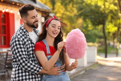 Photo of Happy couple with cotton candy spending time together outdoors