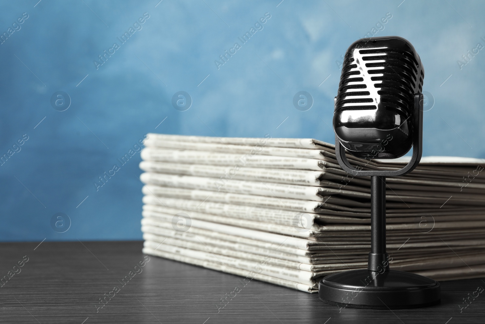 Photo of Newspapers and vintage microphone on table. Journalist's work