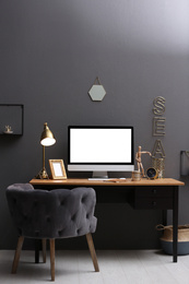Photo of Modern computer on table in stylish office interior