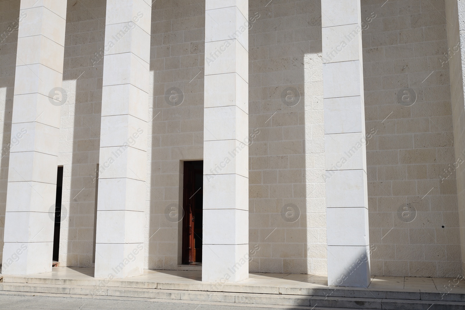 Photo of View of modern beige building with columns outdoors