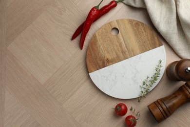 Photo of Cutting board and different spices on wooden table, flat lay. Space for text