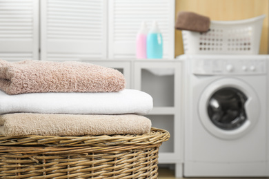 Fresh towels on wicker basket in laundry room