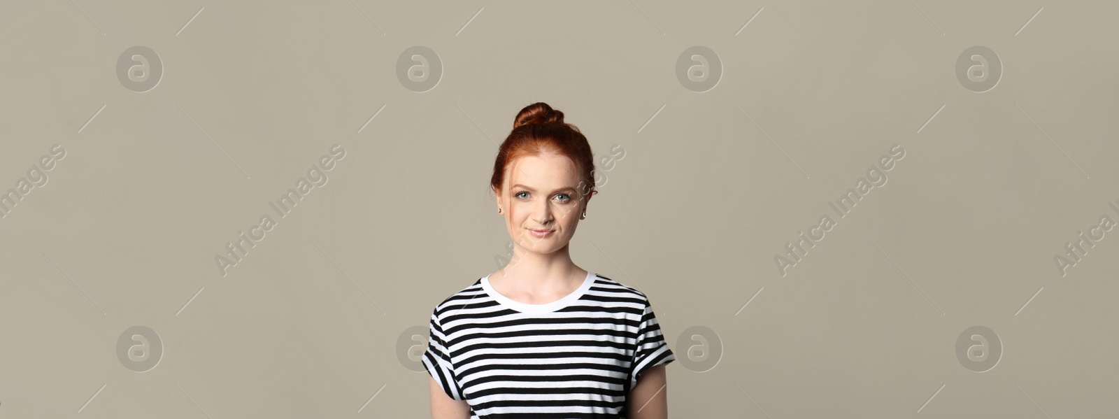 Image of Candid portrait of happy red haired woman with charming smile on beige background. Horizontal banner design