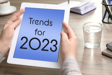Image of Trends For 2023 text on tablet display. Woman using gadget, closeup